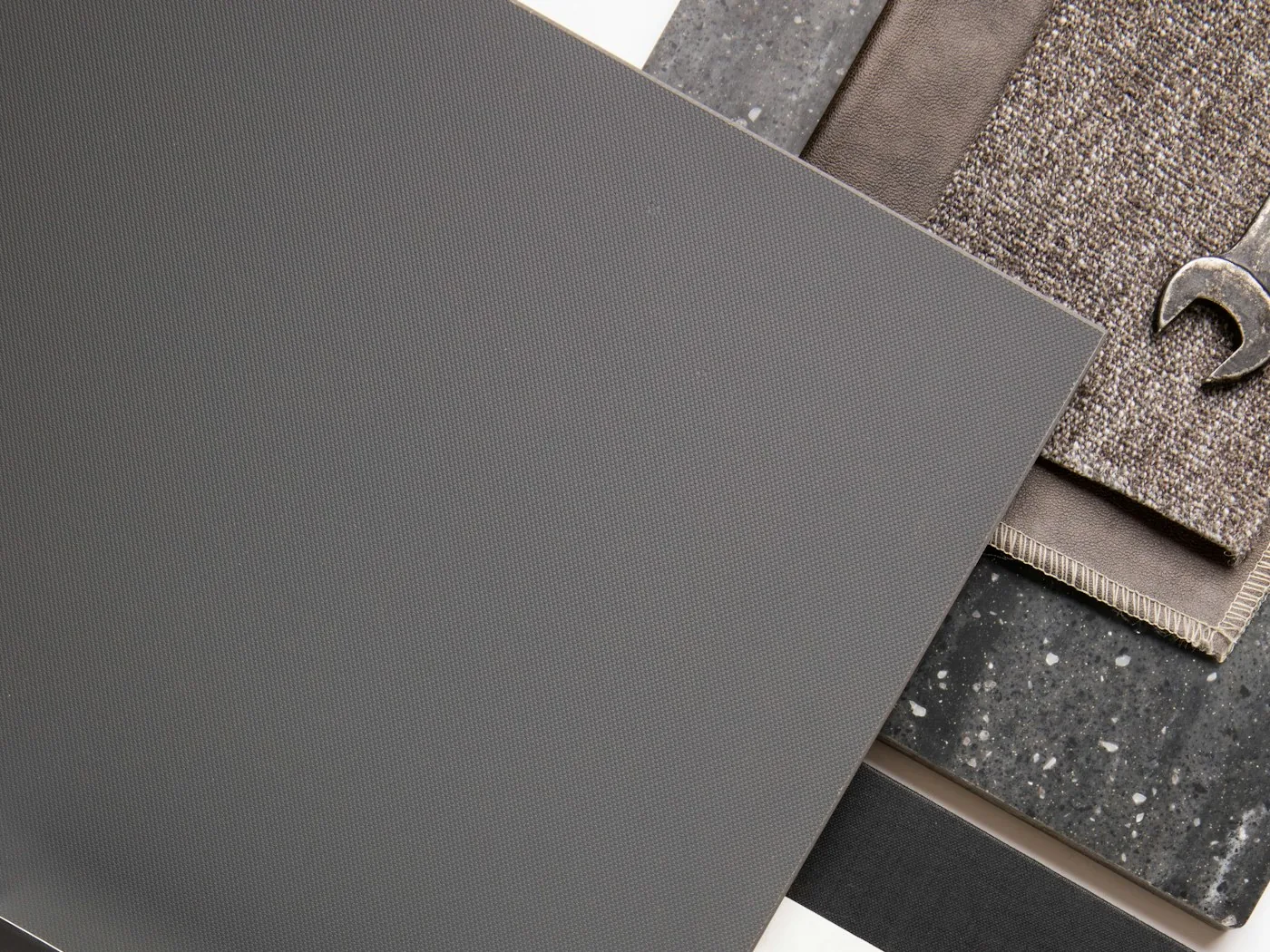Curated arrangement of interior material samples — stone, leather and textile finishes