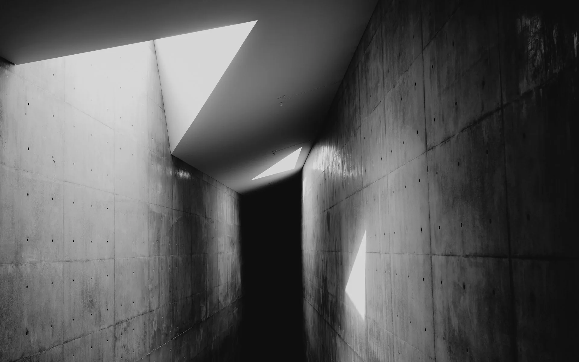 Concrete corridor with dramatic triangular light and shadow