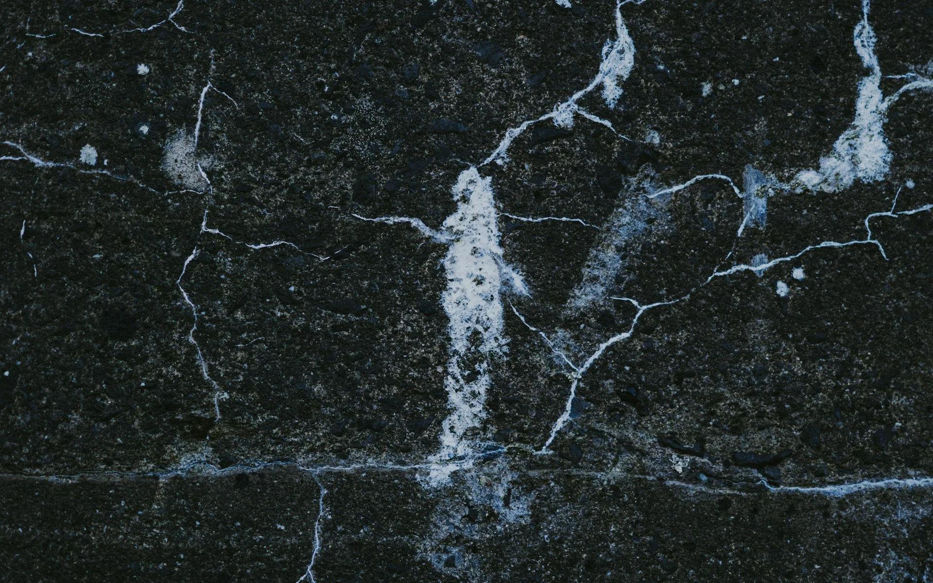 Extreme close-up of dark natural stone with fine white veining
